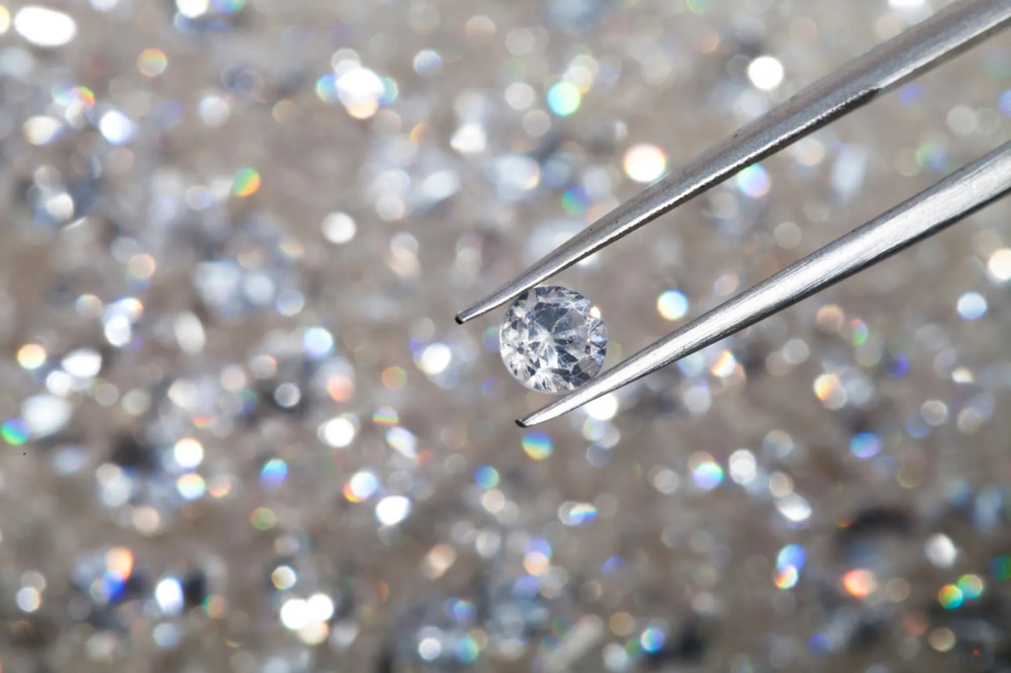 Brilliant-cut diamond close-up with shimmering bokeh background.